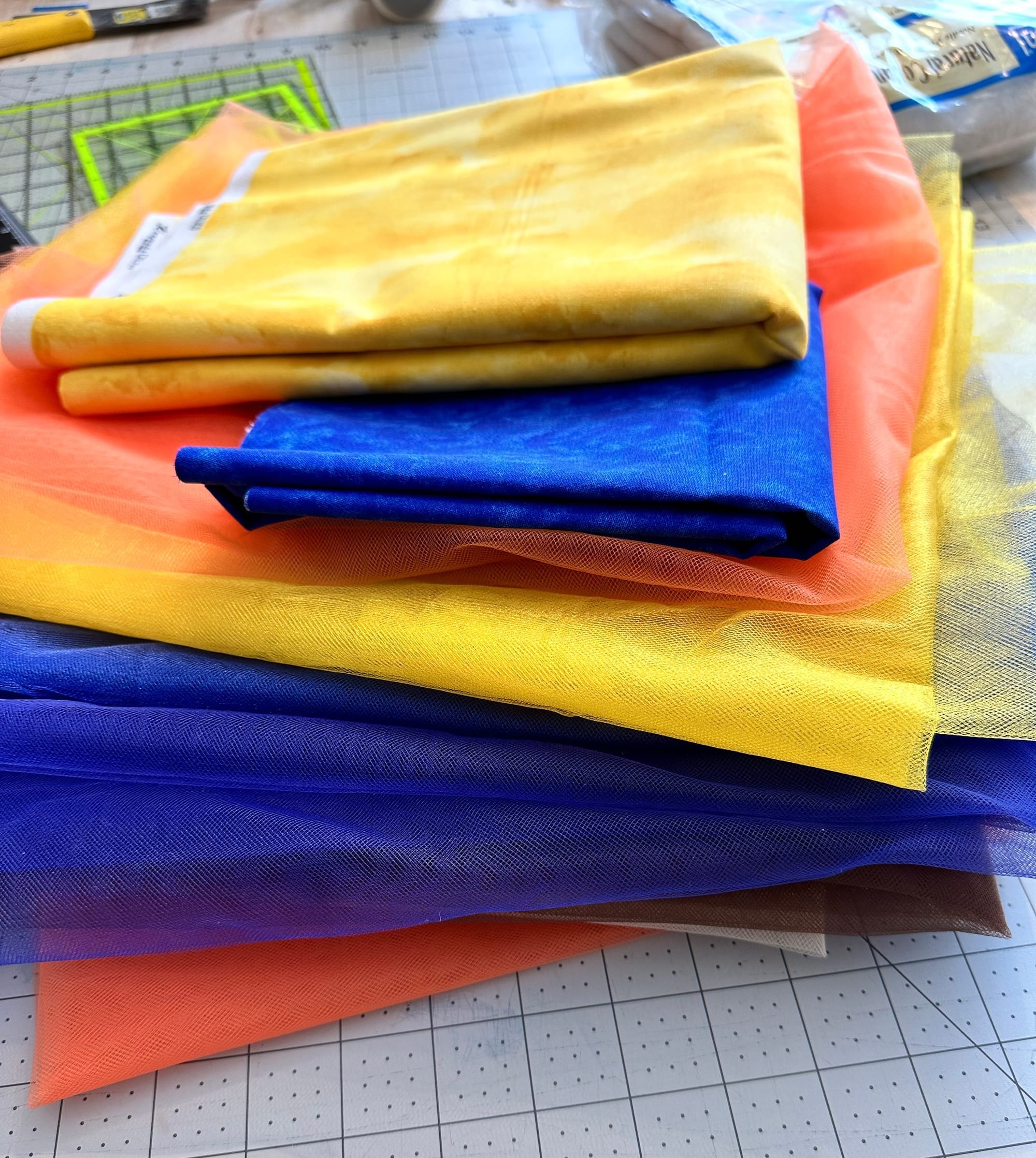 a stack of blue, orange, and yellow fabric on a grey mat